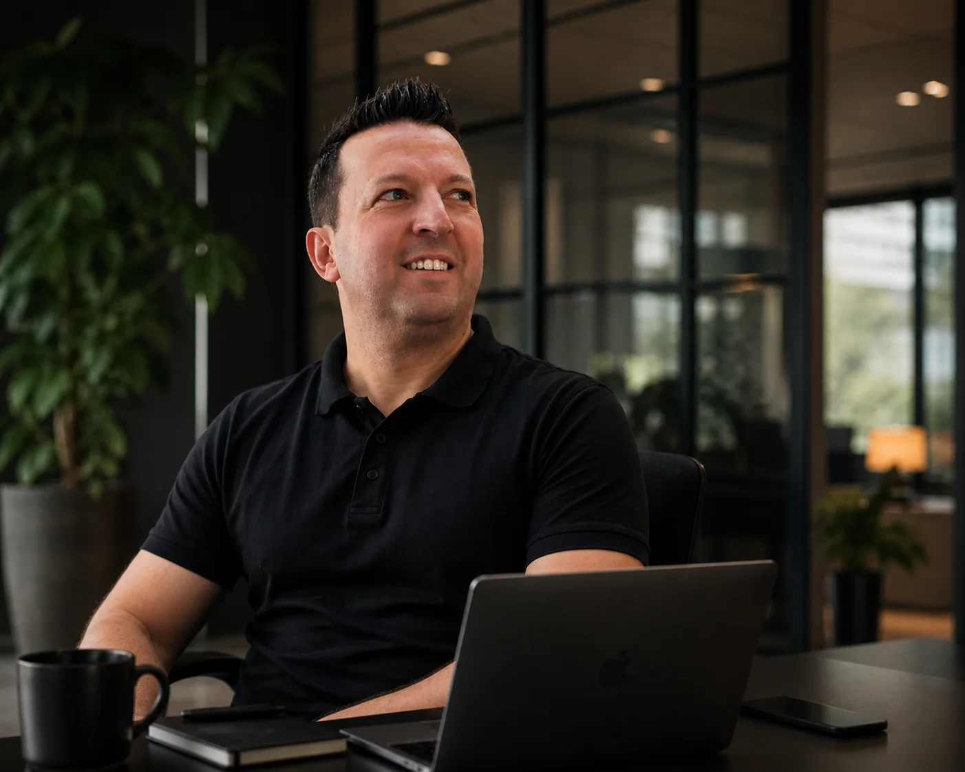 Evangelos Malousis von Flovaro am Laptop in einer modernen Arbeitsumgebung